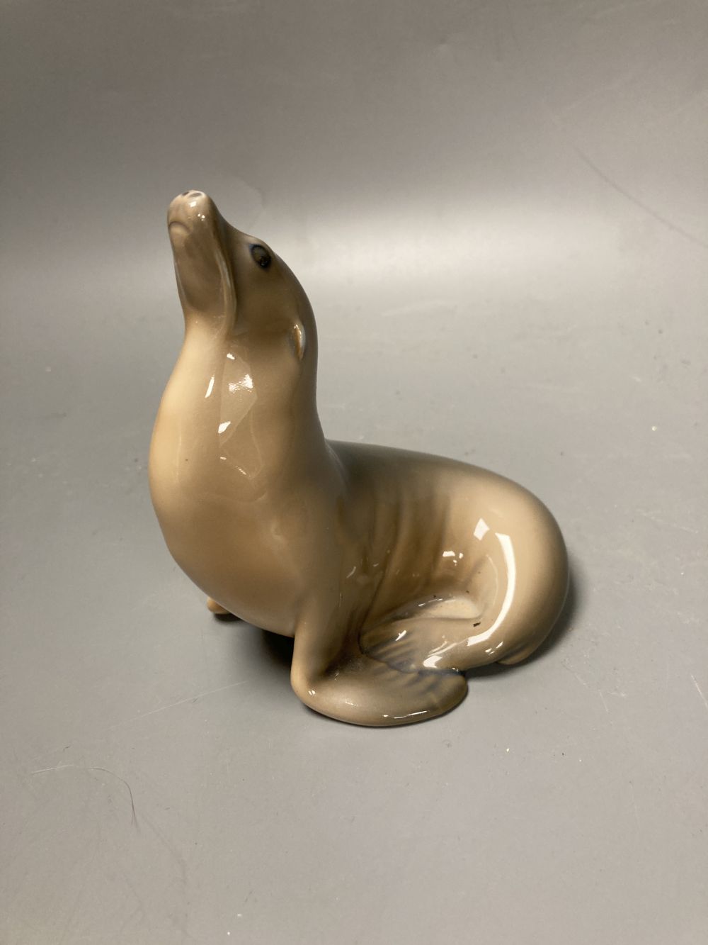 Two Lladro porcelain figures and a Royal Copenhagen model of a seal, tallest 26cm